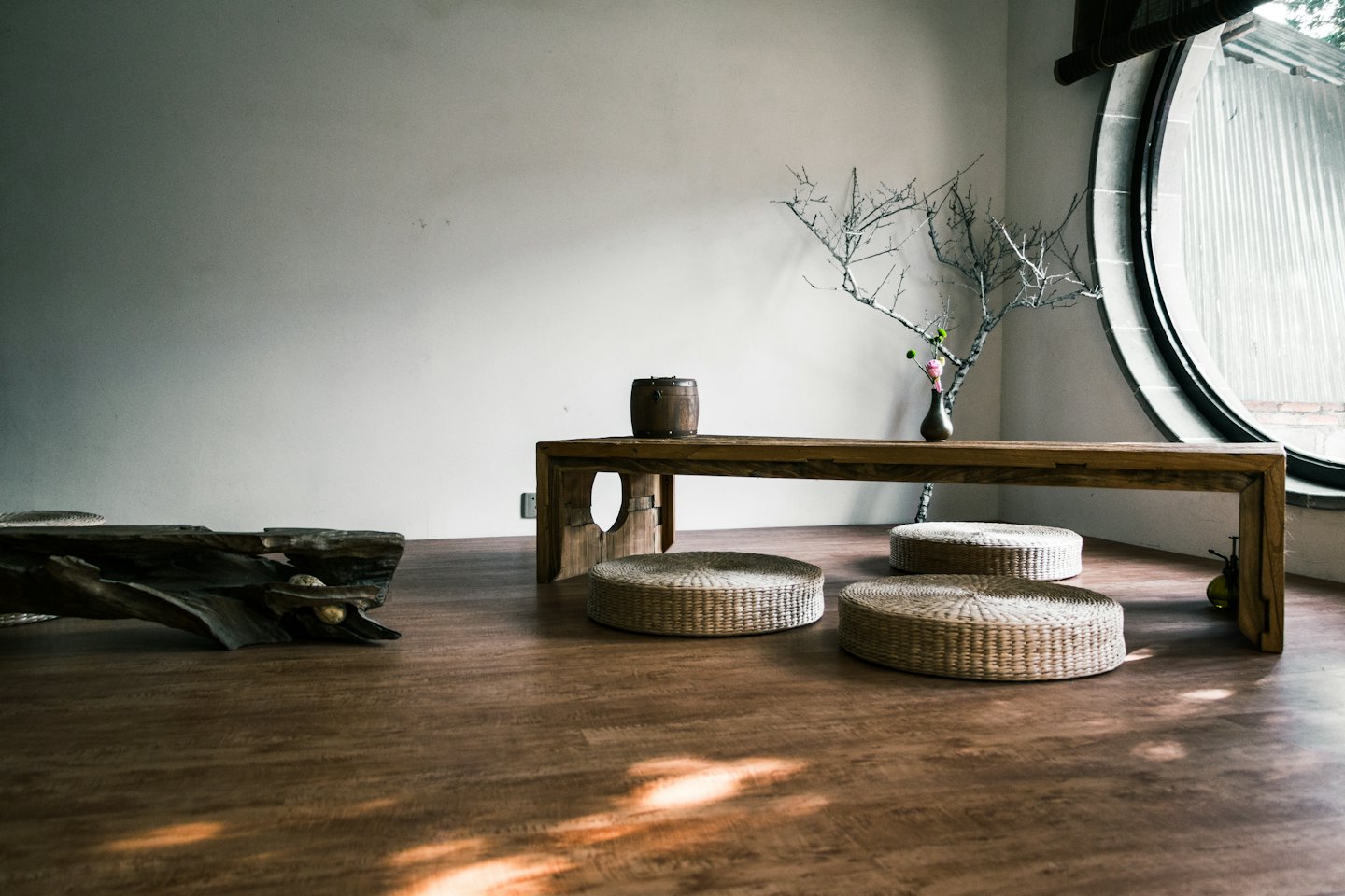 Minimalistische kamer met lage houten tafel en vloerkussens.