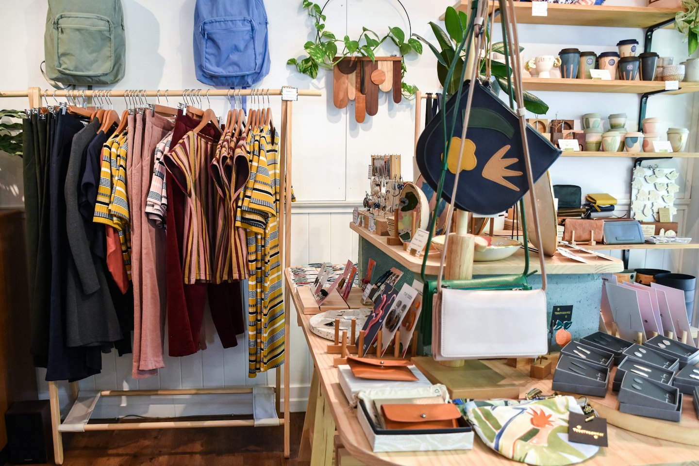 Interieur van een boetiek met kledingrekken en schappen waarop merchandise wordt tentoongesteld.